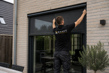 Monteur van Exact Zonwering monteert een screen aan een woning