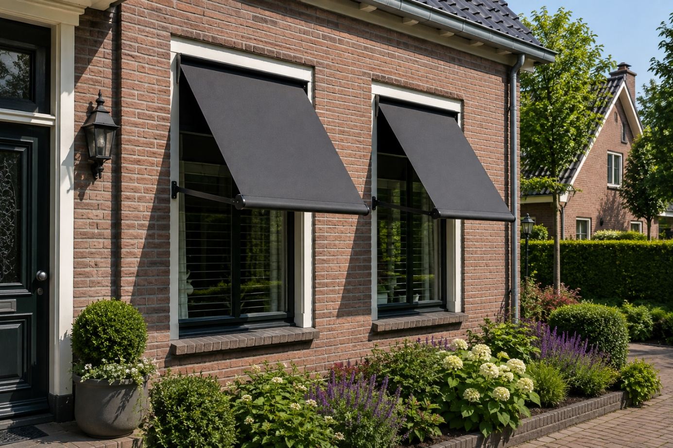 Antraciet uitvalscherm boven twee ramen aan een bakstenen woning
